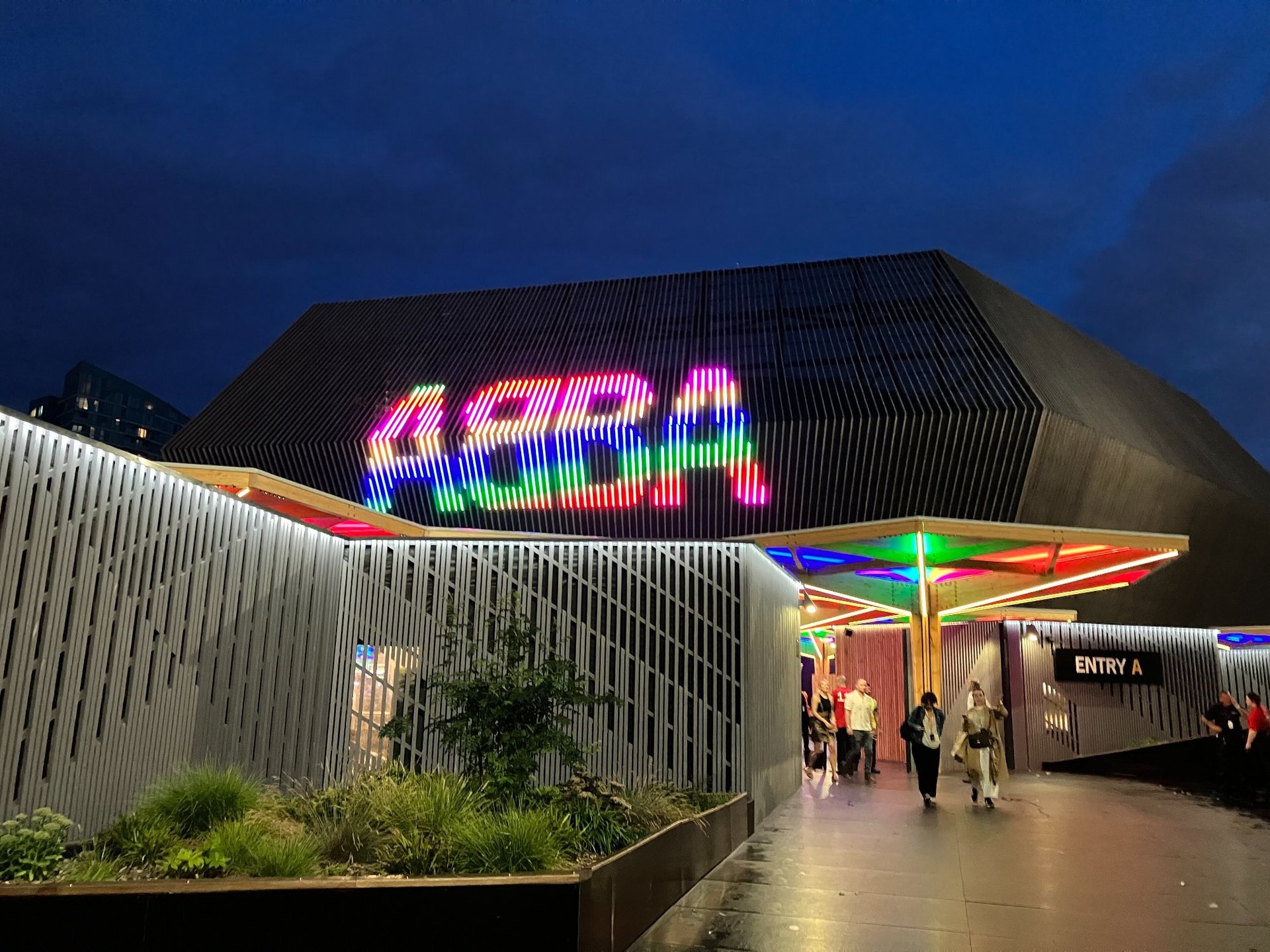 ABBA Arena London at night with rainbow neon sign